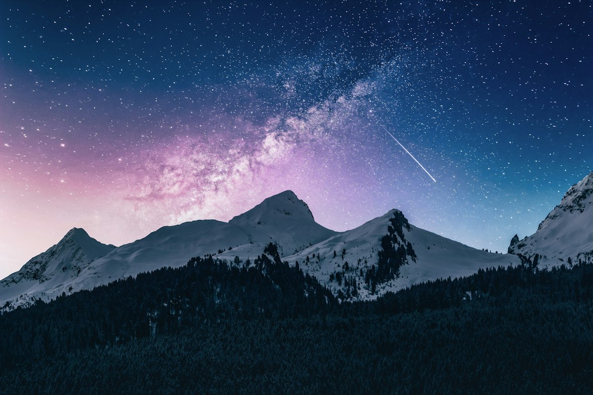 Starry night over snowy mountain peaks